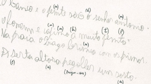 Caderno com um exercício de escrita manuscrita, com letras irregulares e anotações a lápis sobre as palavras